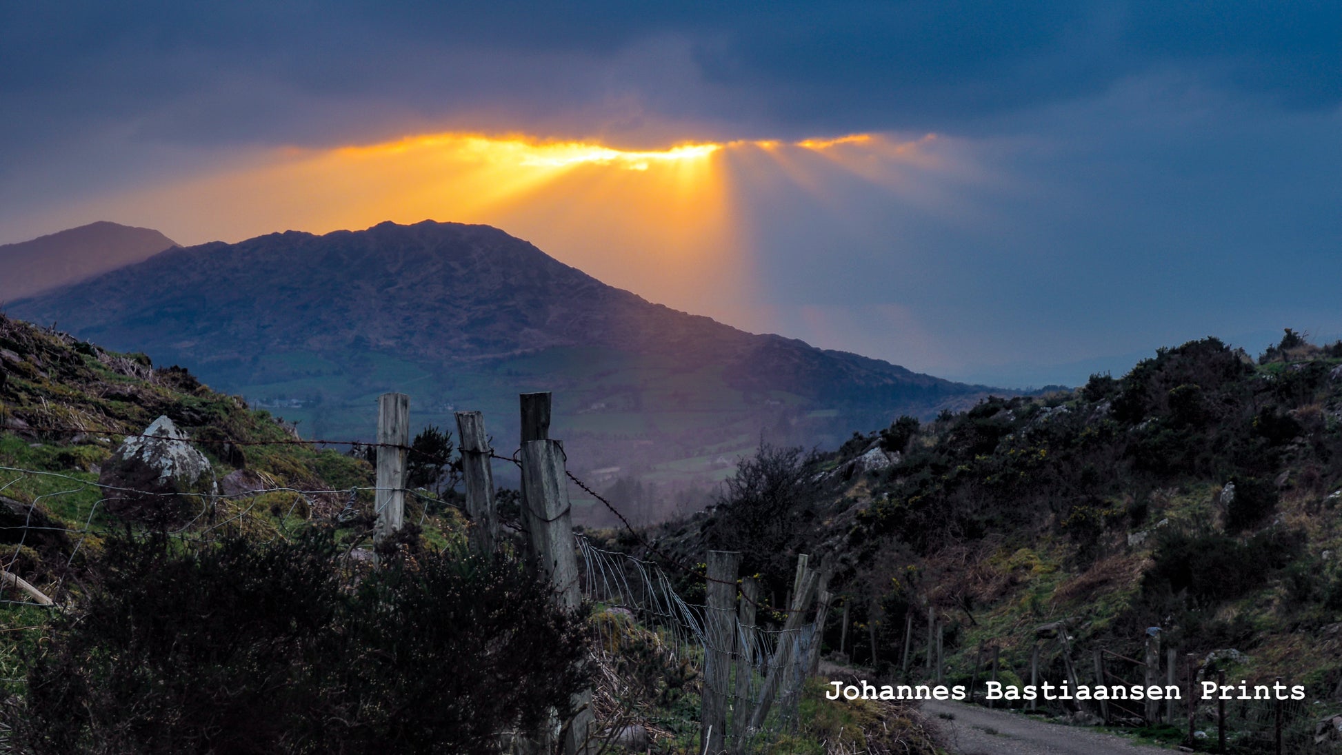 Light streams through a break in the cloud over mountains